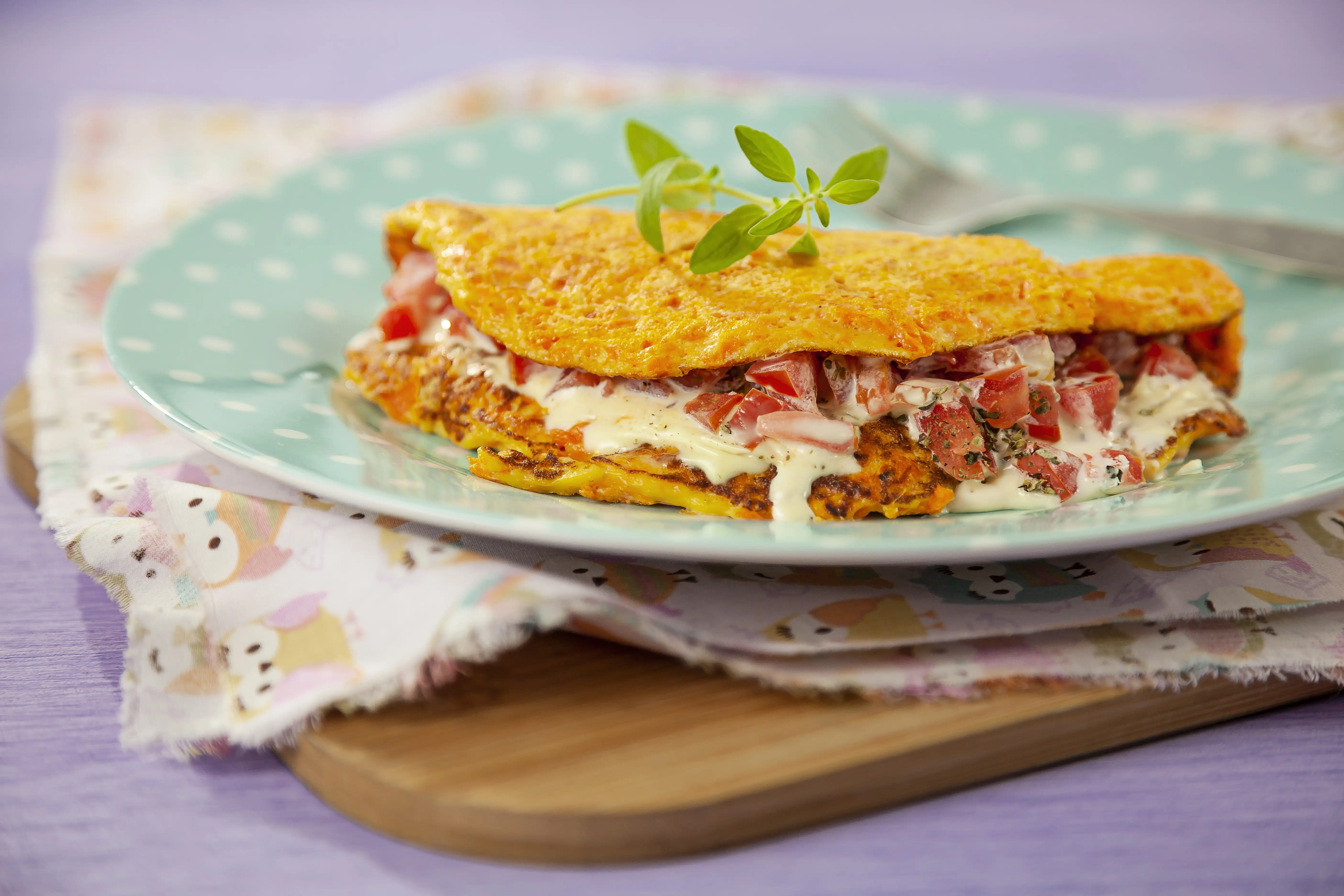 Crepioca recheada dourada com tomate e queijo no prato